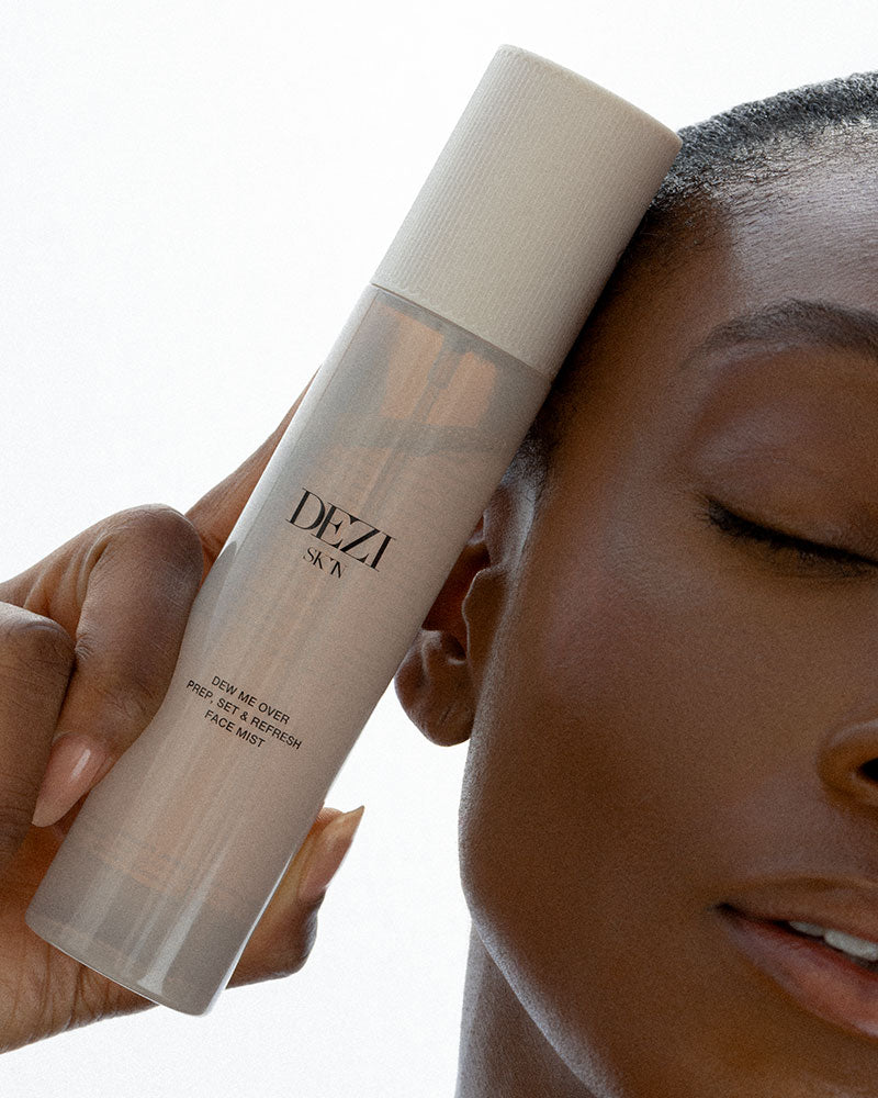 Model holding the skincare mist bottle next to her face.