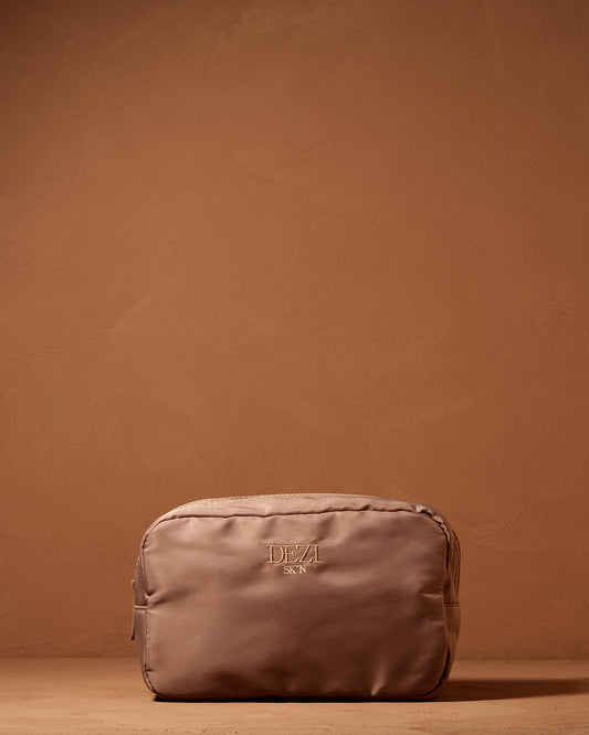 This is a picture of a small cosmetic / toiletry bag. It is a beautiful neutral brown color. Made of nylon with a zipper on the top.