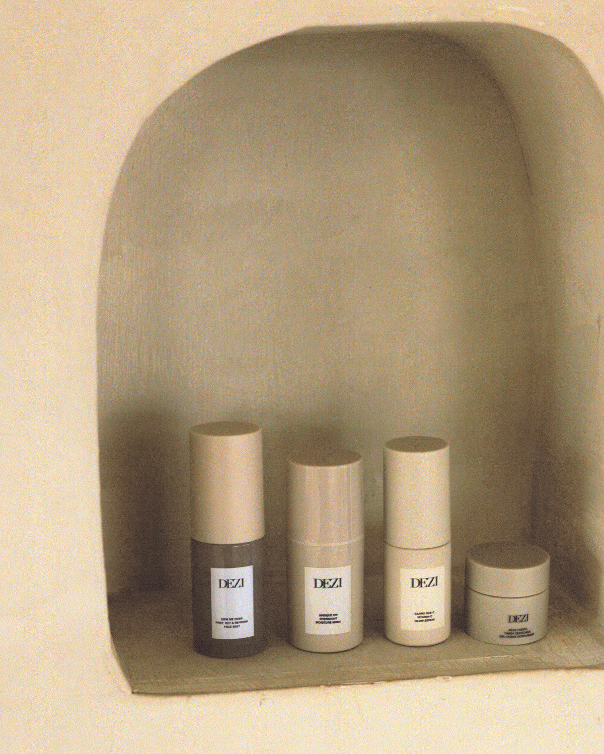 Four mini travel size skincare products sitting on a shelf