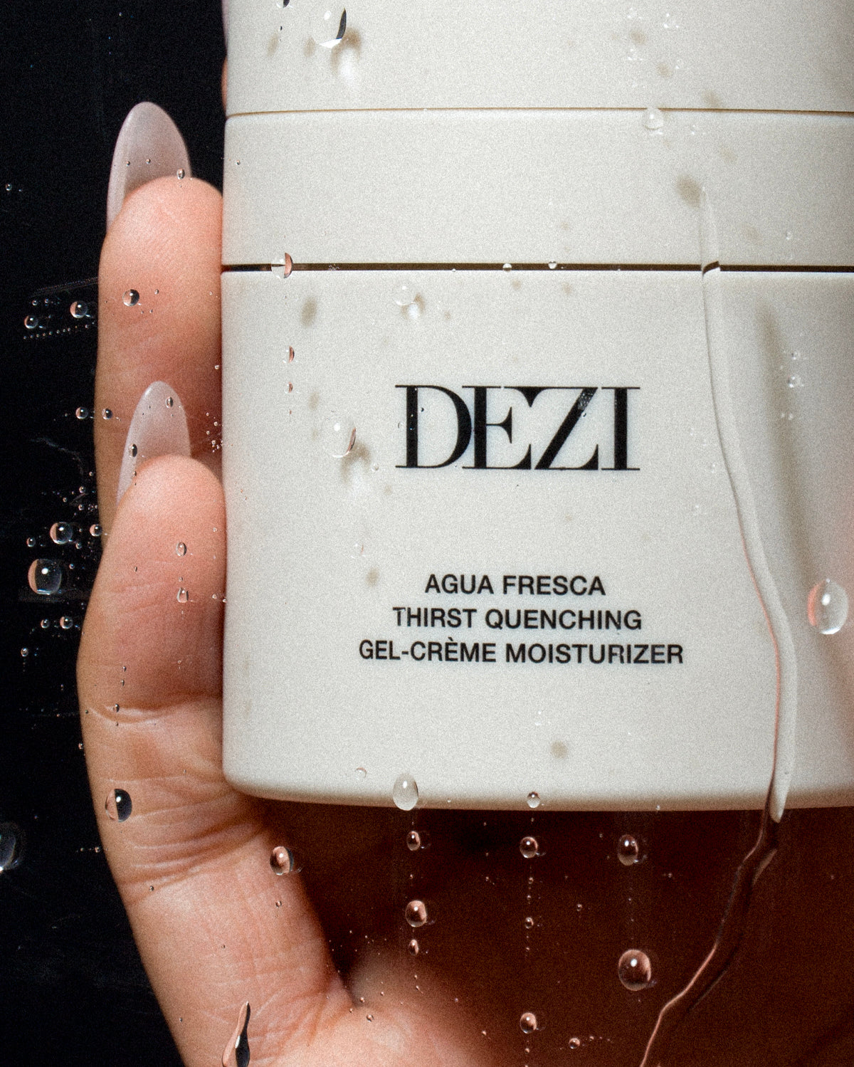 This shows the moisturizer jar being held in a hand. The cap is on it and it has water droplets. You can see that the product must be very hydrating. 