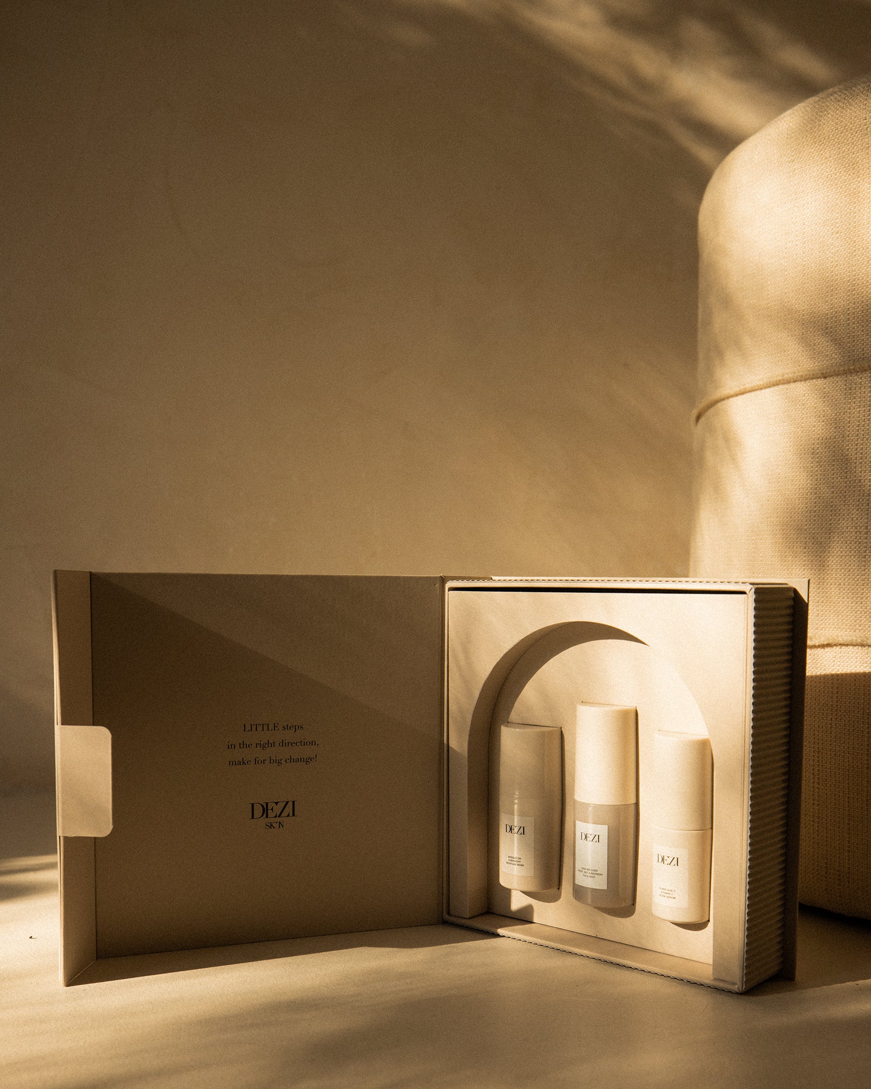 This shows three DEZI SKIN travel size products in the custom box. They are sitting in a tray that is shaped like an arch, inspired by architecture.
