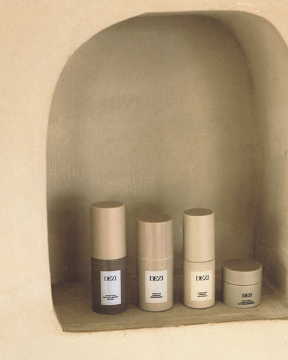 Four mini travel size skincare products sitting on a shelf
